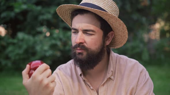 Closeup of Young Male Farmer Looking at Green and Red Bell Pepper Smelling Organic Vegetable Smiling alt
