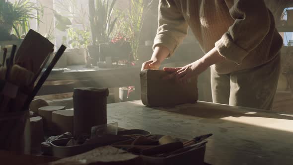 Woman Is Cutting Raw Clay With String Tool alt