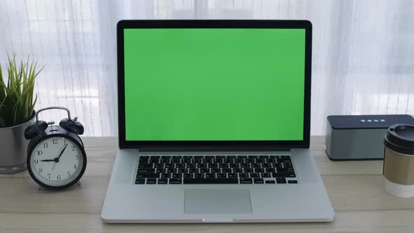 Chroma key green screen of laptop computer set on working space in home office alt
