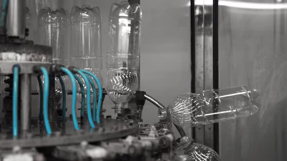 Plastic Bottles Travel Through an Automated Bottling Line for Drinking Water