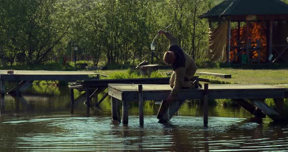 Man Fishing on Wooden Pier Near Lake