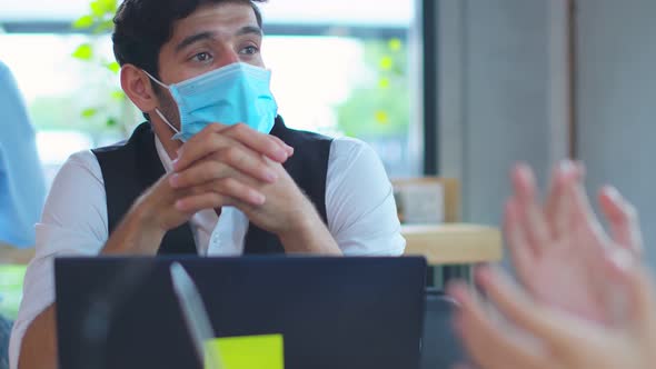 business meeting Freelance caucasian male and asian female putting protective face mask alt