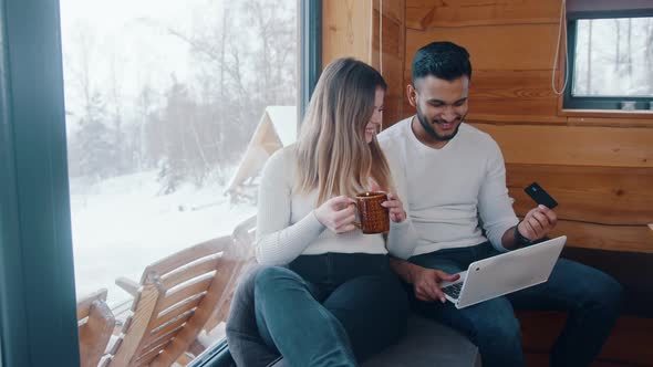 Happy Young Multiracial Couple Using Credit Card To Do Online Shopping alt