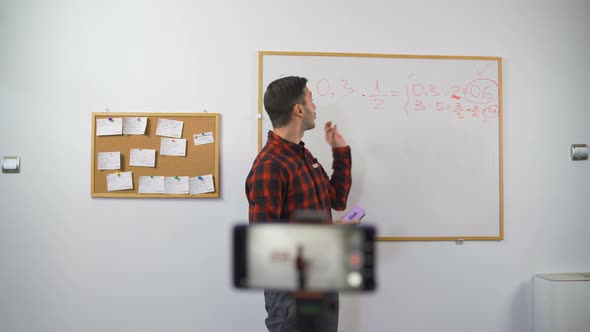 Math Teacher Explains Online Lesson To Students Using Marker and White Board alt