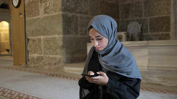 Hijab Woman Reading Quran Smarthphone alt