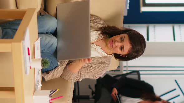 Business Woman Talking During Video Conference Calling From Laptop Sitting on Couch alt