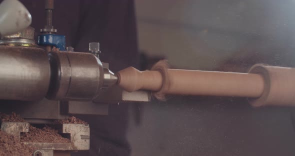 Artist creating a buddhist prayer wheel on a lathe alt