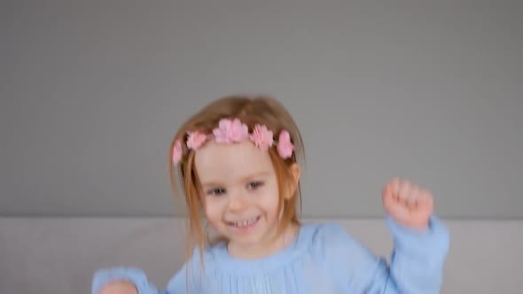 Cute happy little girl jumping on bed