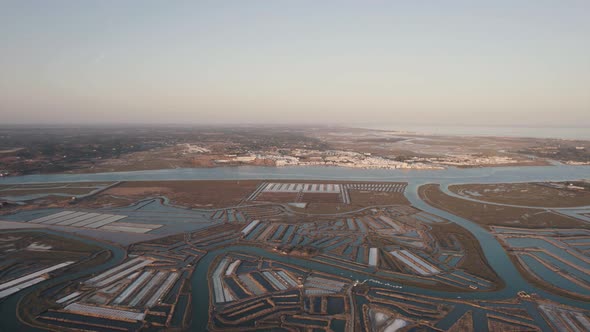 Aerial dolly out shot reveals the spectacular view of vast expanse of salt pans in Castro Marim. alt