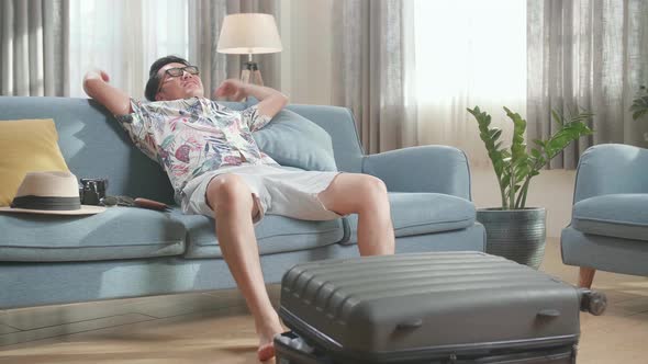 Asian Man Preparing For Travel Adventure, Packing Clothes Into Suitcase, Getting Ready For Road Trip alt