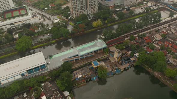 Aerial Rotating Shot of the Top of a Parking Garage with One Car in Urban City in Asia alt