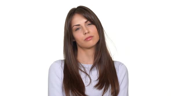 Displeased Attractive Young Caucasian Female Standing Over White Background in Slowmotion alt