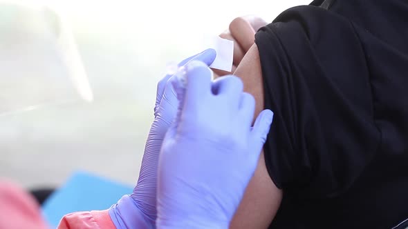 Close-up video of a man's arm being injected with the corona virus vaccine alt