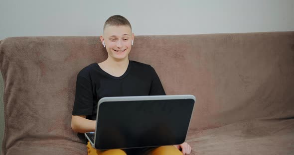 Guy looks into black laptop display at online lesson alt