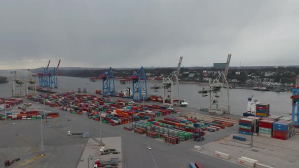 Slow Aerial Dolly in of Large Industrial Cargo Container Port By the River in Hamburg Germany alt