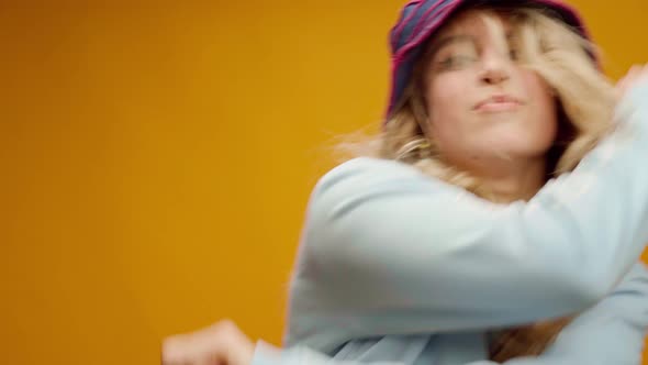Young Happy Woman in Panama Hat Dancing on Yellow Background alt