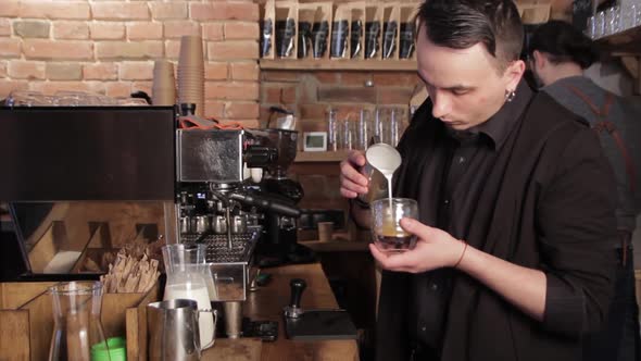 Barista making coffee latte art. Pouring milk into cappuccino.