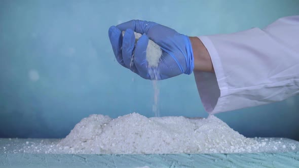 Hand in Blue Glove Scientists Check Deicer Reaner Against Ice alt