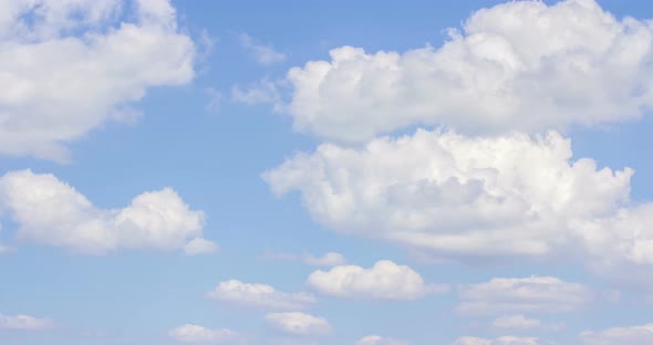 The motion of clouds on the background of the azure sky.