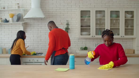 Positive Dad Motivating Teenage Daughters Involved in Housework alt