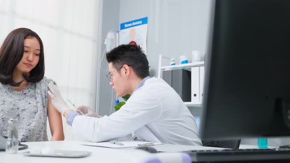 Asian man doctor wear glove, give treatment to young woman in hospital. alt