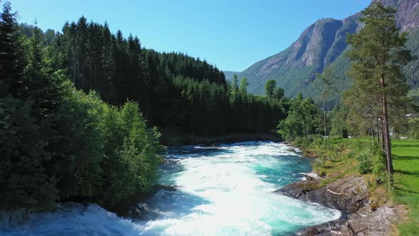Huge turquoise crispy glacial river flowing down from lake Lovatnet Norway - Melted glacier ice from alt