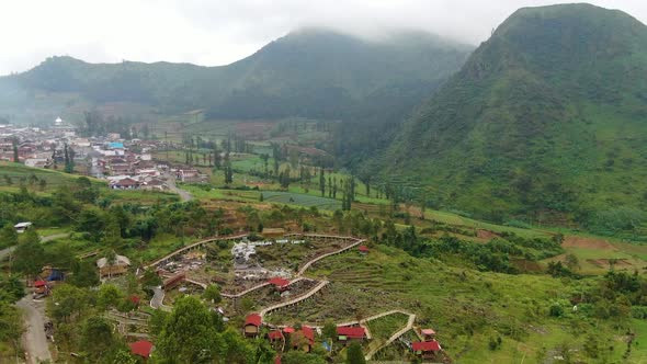 Outskirts of Wonosobo city, Java, misty mountains and farmland aerial view alt