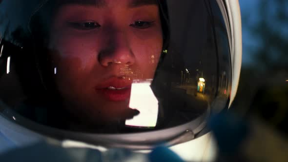Close-up of Asian astronaut looking at digital device