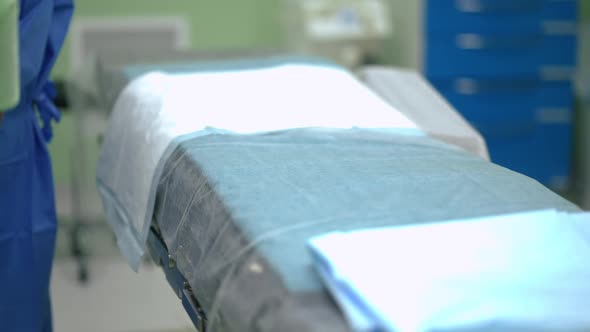 Operation Bed in Surgery Room in Hospital with Unrecognizable Nurse Indoors alt