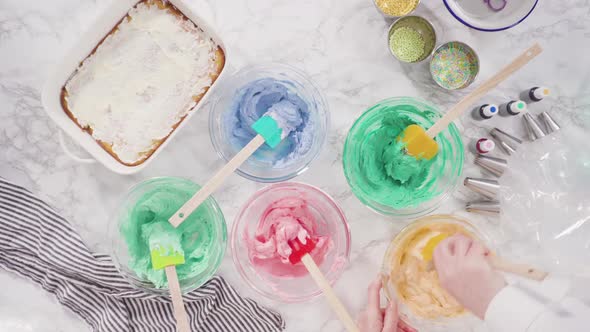 Flat lay. Mixing food coloring into Italian buttercream frosting. alt