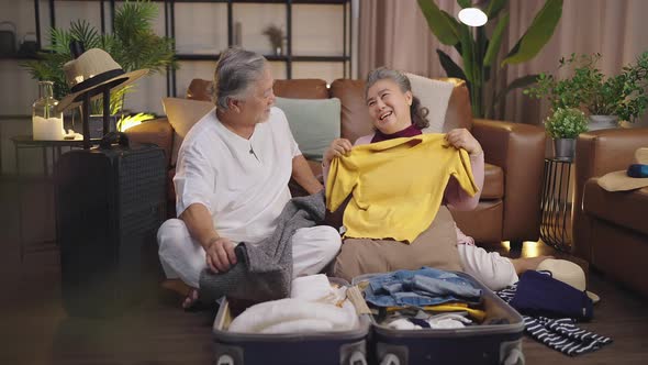 happiness asian old age retired mature adult enjoy arrange cloth together on floor