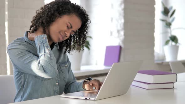 Tired African Girl with Neck Pain While Working on Laptop alt