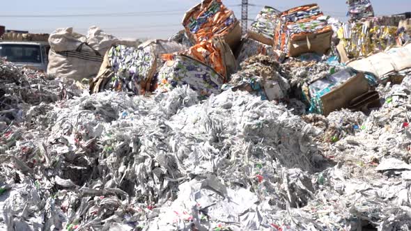 cinematic shot of shredded paper at a recycling plant alt