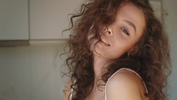 A Young Woman is Looking at the Camera and Turning Her Head alt