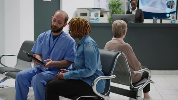 Female Patient and Medical Assistant Looking at Digital Tablet alt