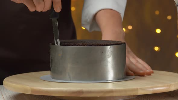 Closeup of the Chef Removing a Metal Ring Mold From a Carrot Cake with Caramel alt