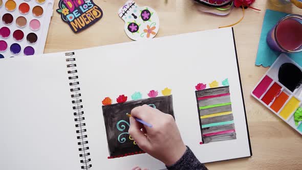 Step by step. Flat lay. Baker sketching a design of a cake with watercolors for Dia de los Muertos h alt