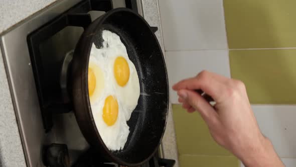 Vertical Video Young Man Preparing Scrambled Eggs Frying Pan Home Kitchen alt