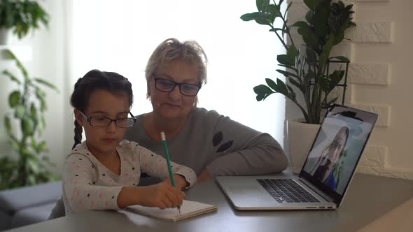 Little Girl Studying with Her Grandmother at Home Use Laptop for Education Online Study Home
