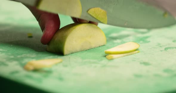 Chef Slicing Fresh Green Apple On The Chopping Board In The Restaurant Kitchen - slow motion alt