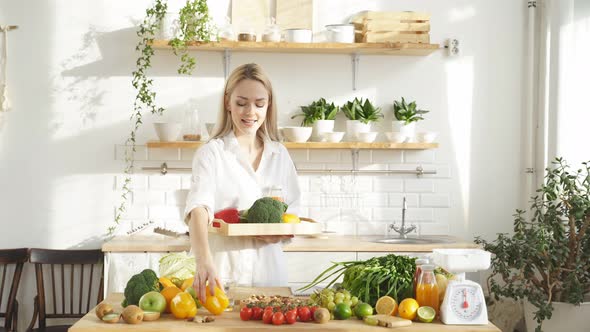 Female Food Blogger Tells the Camera What you Can Cook in the Kitchen with Fresh Vegetables alt