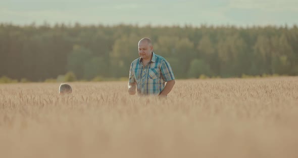 Child with His Father are in a Large Wheat Field
