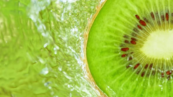 Super Slow Motion Shot of Splashing Water on Rotating Kiwi Slice at 1000Fps alt