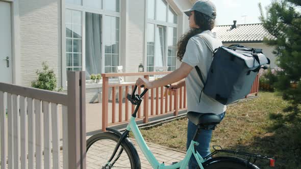 Delivery Worker Girl with Backpack Riding Bicycle Then Knocking on Customer's Door alt