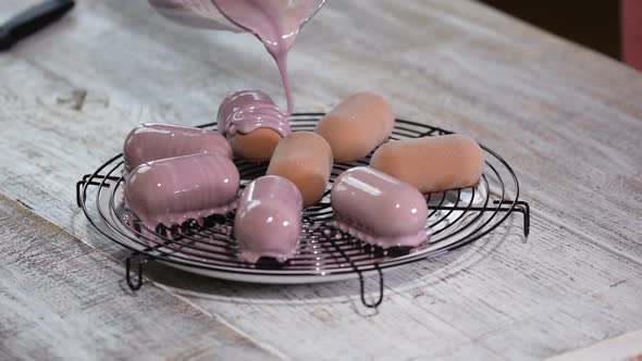 Pouring mousse cake with mirror glaze. Glazing french dessert at confectionery alt