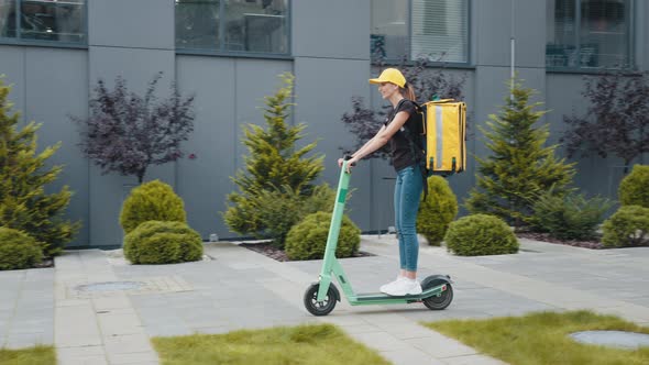 Young Courier Rides on His Escooter alt