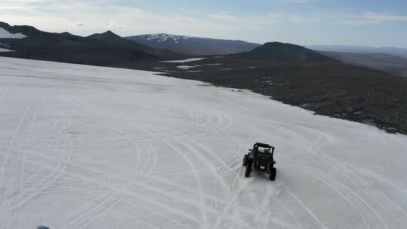 A Quadbike And Snowmobile Drifting Through The Icy Surface Of Langjokull In Iceland. Aerial Tracking alt