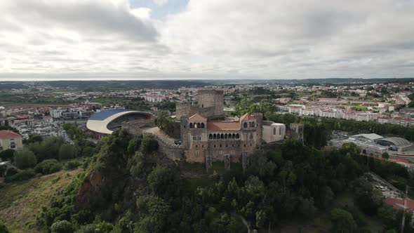 Leiria castle perched on hill and municipal stadium in background, Portugal. Aerial circling
