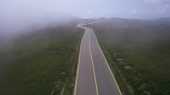 Tracking Drone Shot of Empty Road in Fog Foggy Morning in Rural Area Highway Surrounded By Green