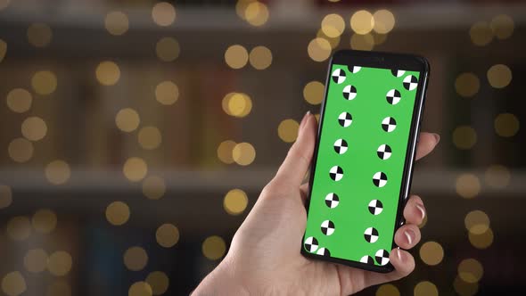 Woman Sliding Pages on a Smartphone with Tracking Points on Display Against Bokeh on Background alt